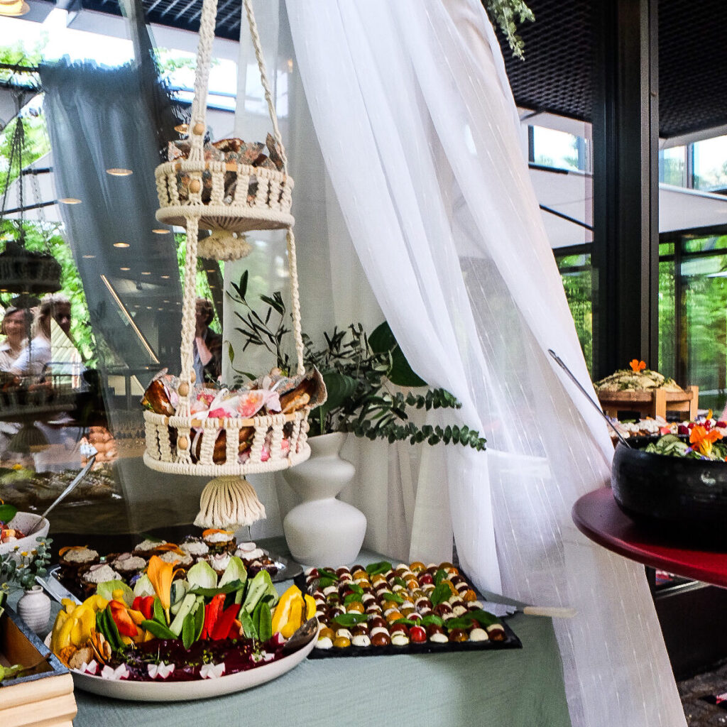 Signature-Picknick-Fotos: „Veganes Signature Picknick von Bananaleaf in einem Münchner Innenhof mit Decken, Kissen und Blumen"